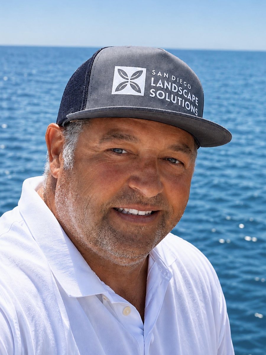 Brett Pieratt, wearing a San Diego Landscape Solutions cap, photographed by the water