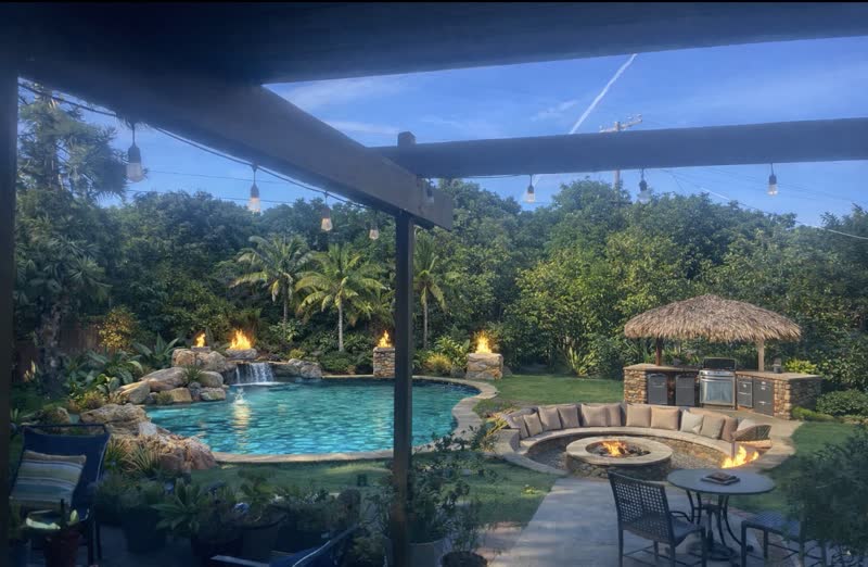 The same backyard rendered with a fire pit and BBQ island